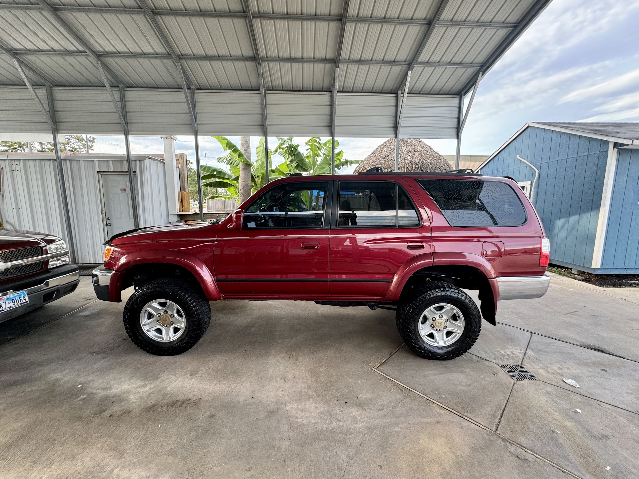 A red Toyota 4Runner parked under the covered carport